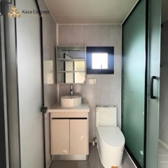Salle d'eau du KAZ Bulma : vasque ronde, miroir, WC et douche vitrée
