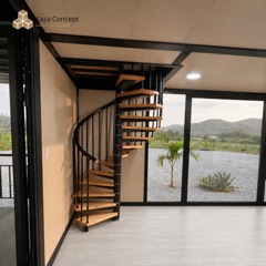 Escalier en colimaçon bois et métal du KAZ Duplex, devant une baie vitrée