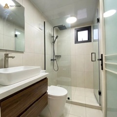 Salle de bain du KAZ Cosy : douche à l'italienne vitrée, WC et vasque sur meuble bois avec miroir